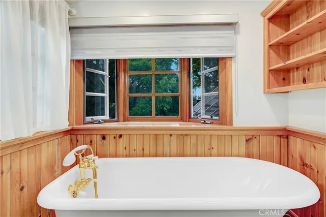a view of en suite bathroom with a tub and window