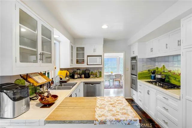 a kitchen with stainless steel appliances kitchen island granite countertop a stove and white cabinets