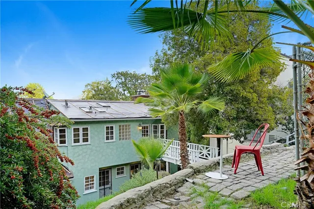 a patio with table and chairs and potted plants