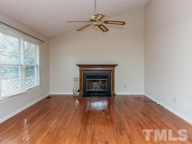7316 Massachusetts Court Raleigh, NC 27615 - Photo 7 of 16 a view of an empty room with wooden floor fireplace and a window