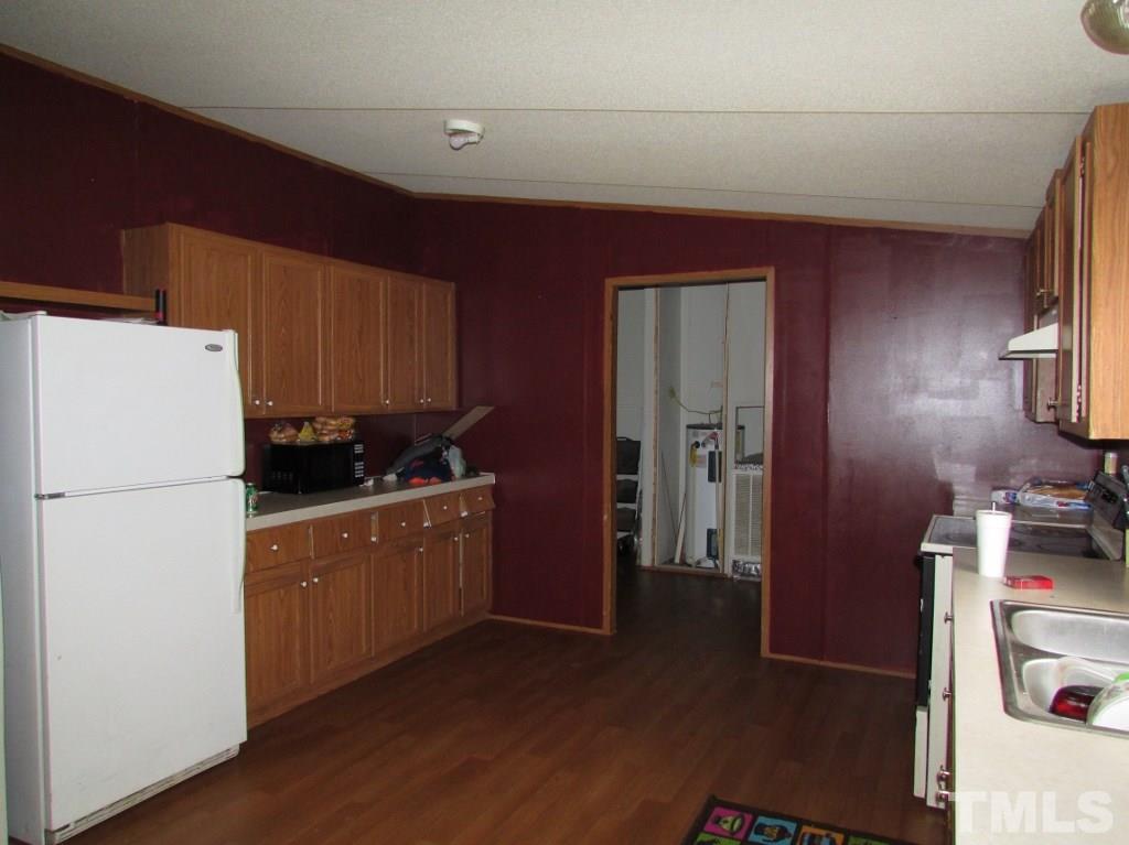 591 Allie Clay Road Roxboro, NC 27573 - Photo 2 of 16 a kitchen with refrigerator and cabinets