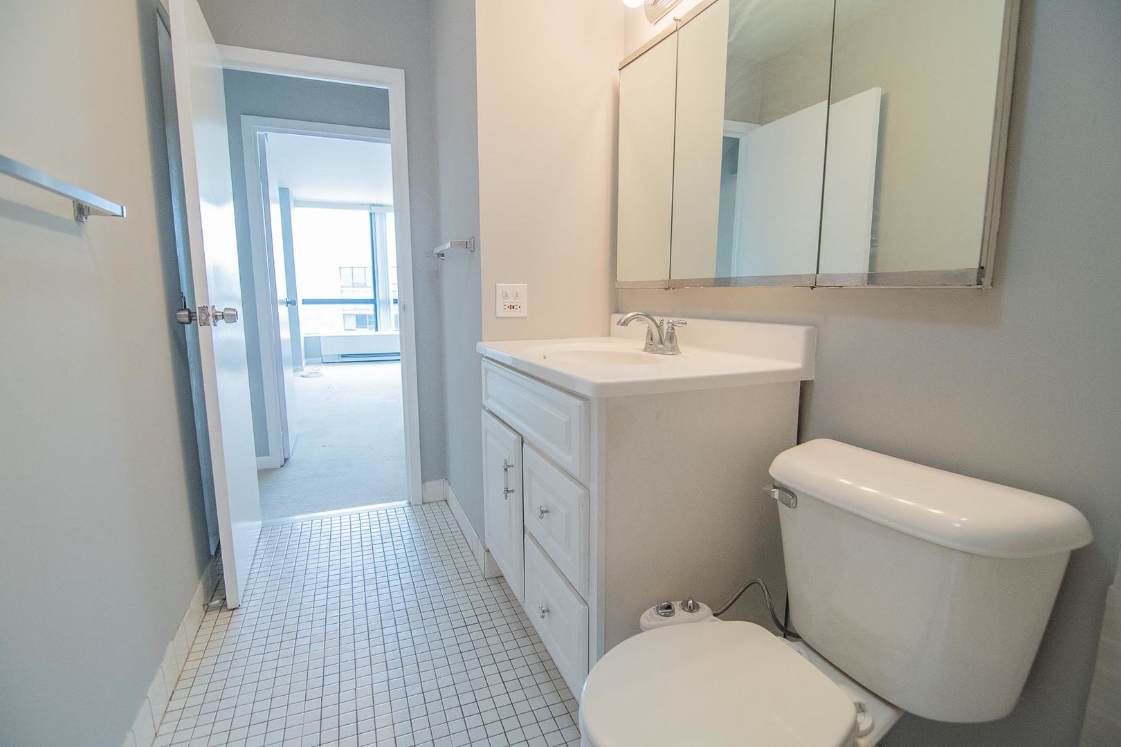 5415 North Sheridan Road, Unit 3808 Chicago, IL 60640 - Photo 11 of 16 a bathroom with a toilet sink and mirror