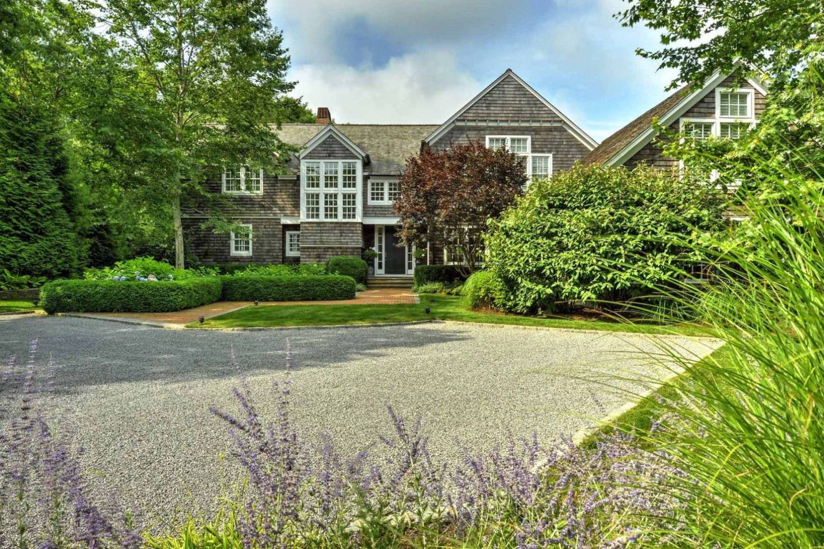 136 Merchants Path Wainscott, NY 11963 - Photo 2 of 17 a front view of a house with a yard and potted plants