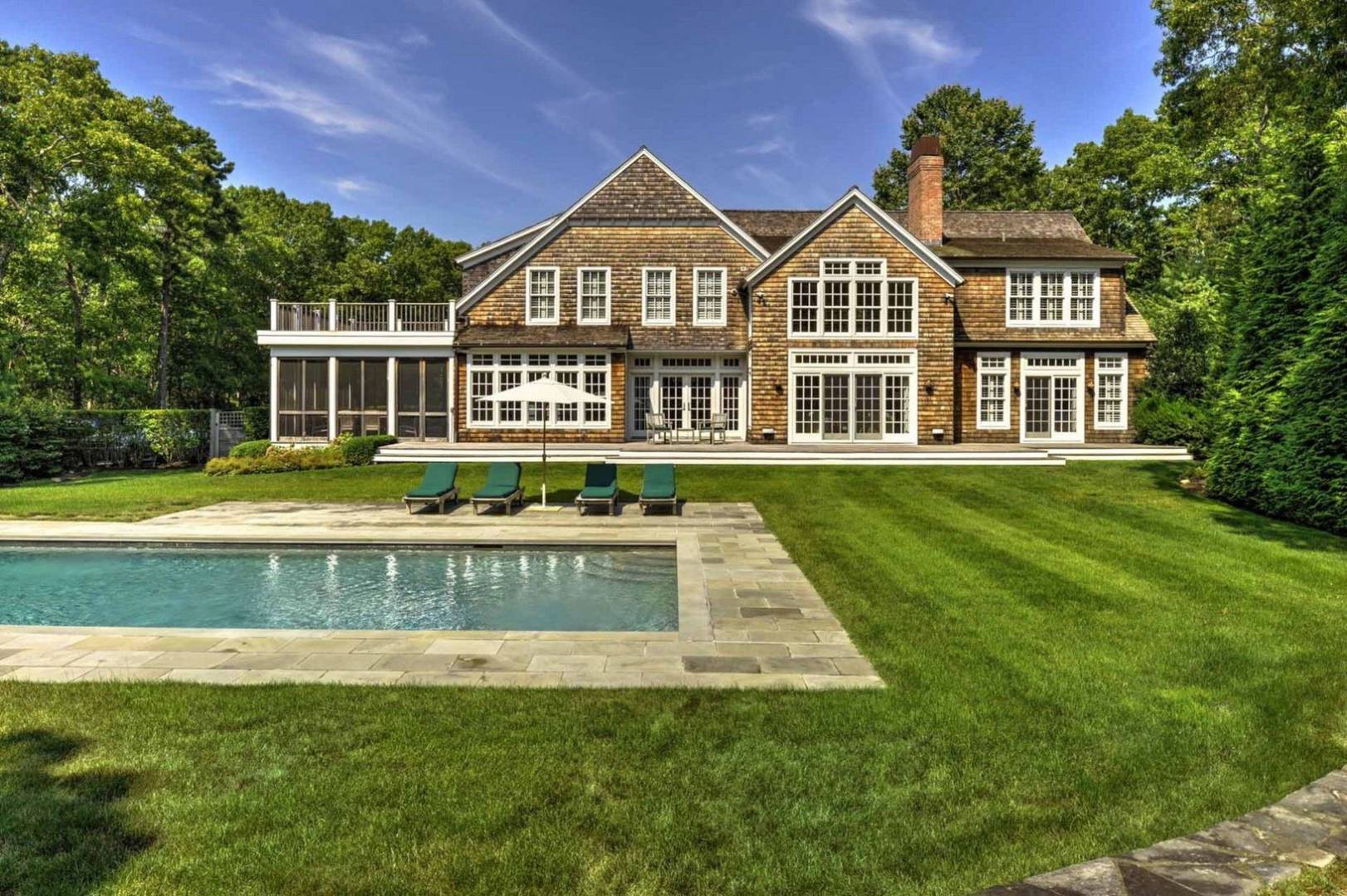136 Merchants Path Wainscott, NY 11963 - Photo 16 of 17 a front view of a house with a yard table and chairs