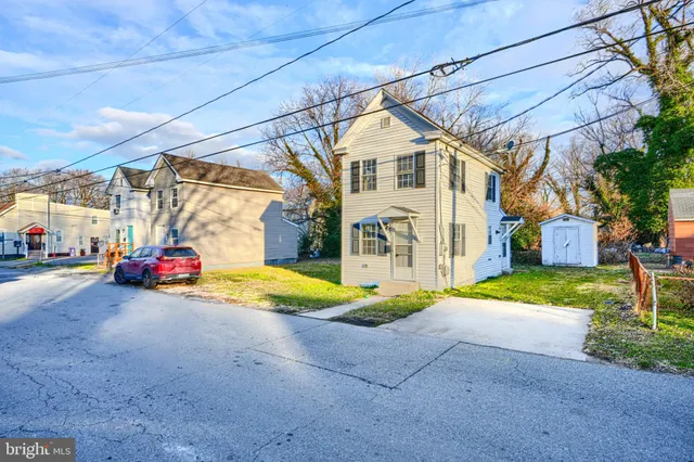 a view of a house with a yard and pathway
