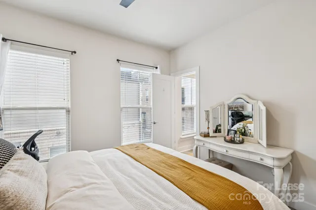 a bedroom with a bed and a large mirror on the dresser