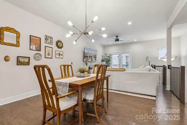 a living room with a dining table wooden floor and a fireplace