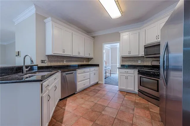 a bathroom with a granite countertop sink a large mirror a vanity and a bathtub