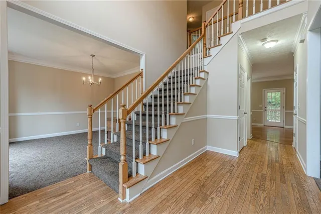 a view of staircase with white walls and wooden floor