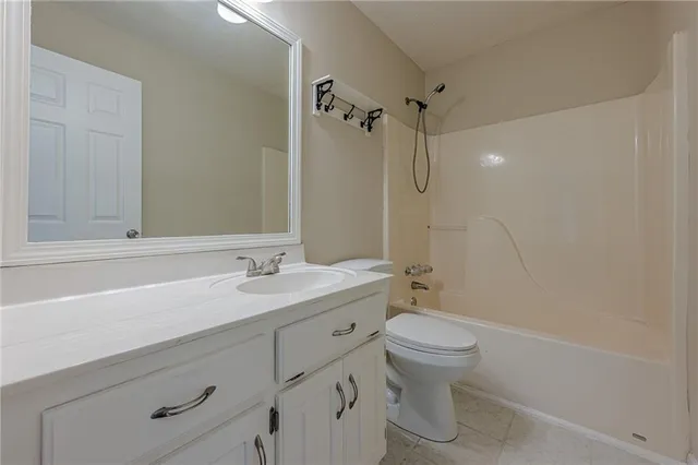 an empty room with chandelier fan and windows