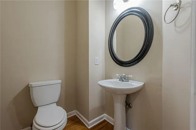 an empty room with wooden floor fireplace and windows
