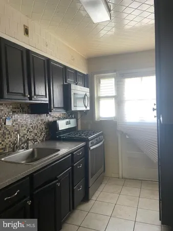 a kitchen with a sink a stove and cabinets