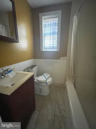 a bathroom with a sink toilet and window