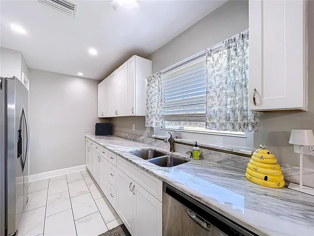 a kitchen with granite countertop a sink and cabinets