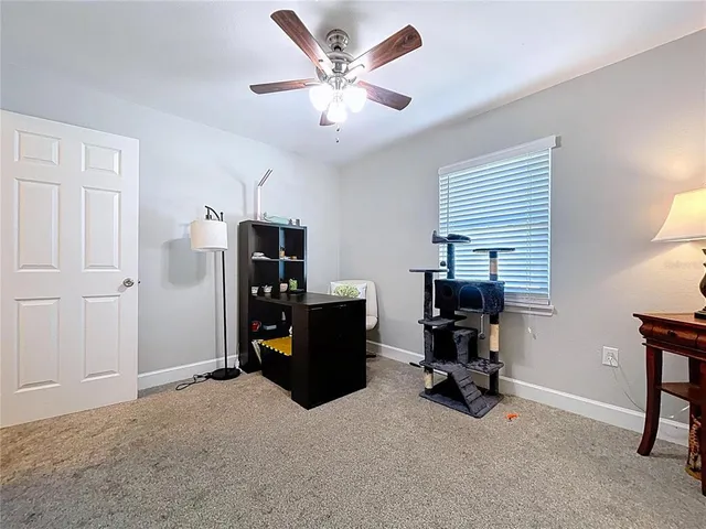 a view of a livingroom with a fireplace a chandelier fan and wooden floor