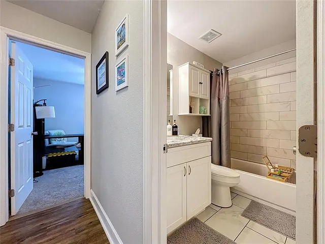 a bathroom with a granite countertop sink mirror vanity and toilet
