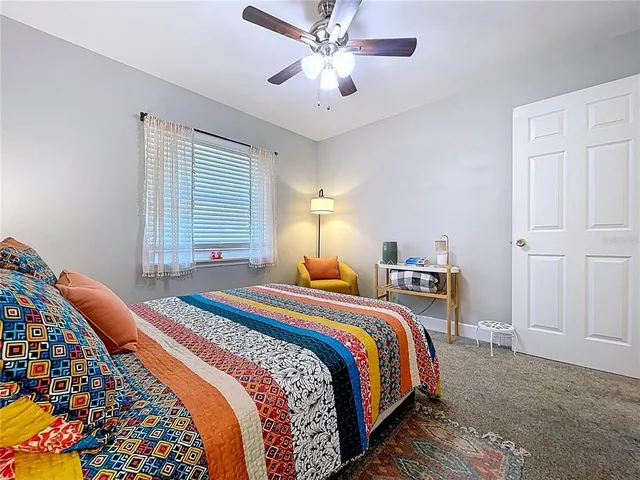 a bedroom with bed and paintings on the wall