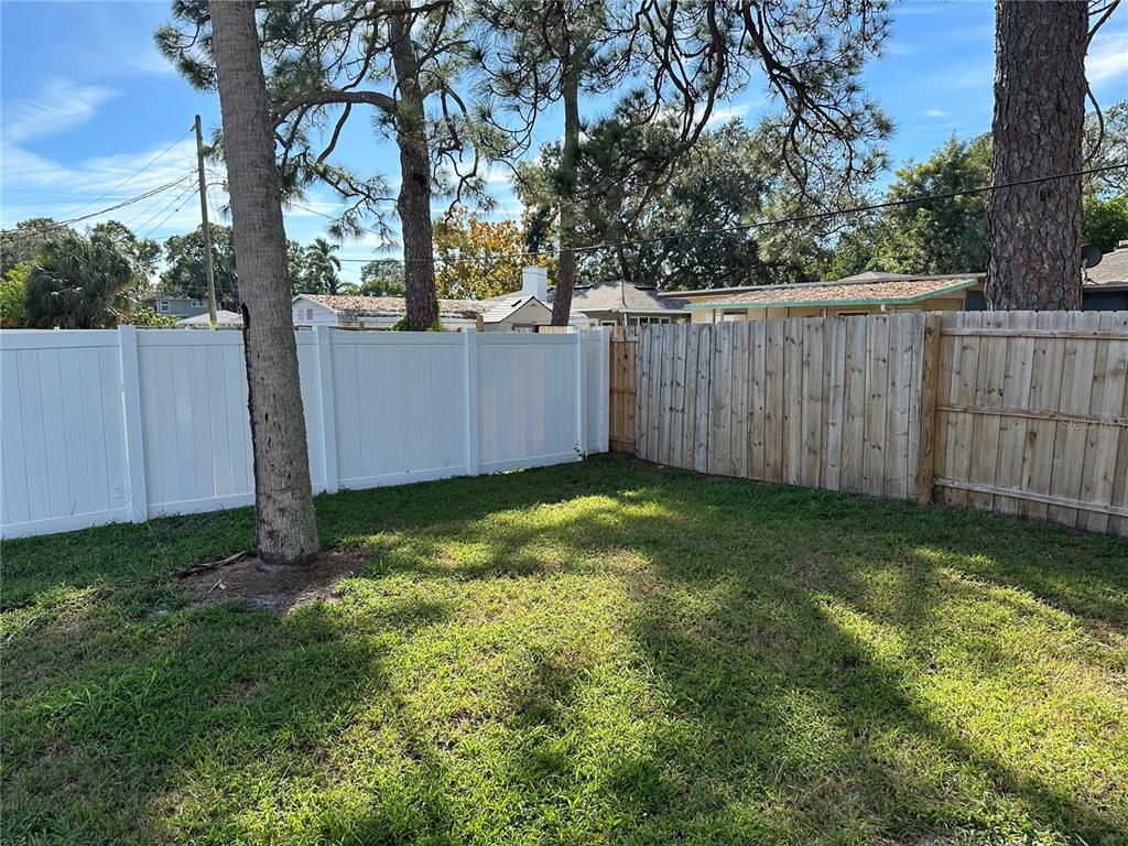 2002 20th Street West, Unit B Bradenton, FL 34205 - Photo 16 of 19 a view of a backyard with large trees and wooden fence