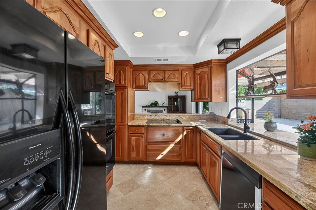 6116 East Paseo Rio Azul Anaheim, CA 92807 - Photo 20 of 54 a kitchen with stainless steel appliances granite countertop sink stove and refrigerator