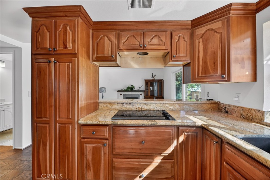 6116 East Paseo Rio Azul Anaheim, CA 92807 - Photo 22 of 54 a kitchen with granite countertop cabinets and black stainless steel appliances with cabinets
