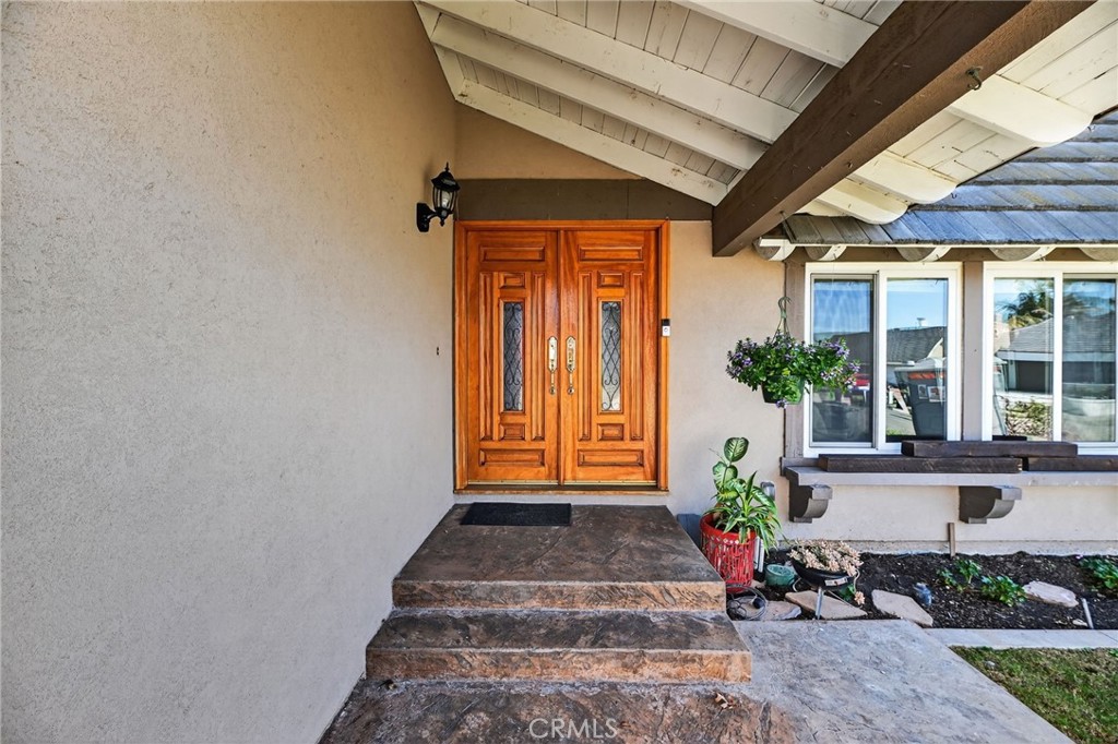 6116 East Paseo Rio Azul Anaheim, CA 92807 - Photo 8 of 54 a front view of a house with potted plants and a table and chairs