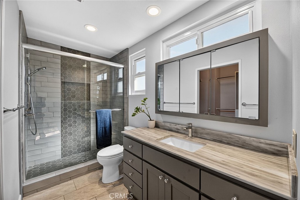 6116 East Paseo Rio Azul Anaheim, CA 92807 - Photo 9 of 54 a bathroom with a granite countertop sink toilet a mirror and shower