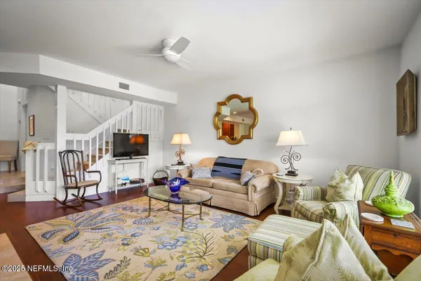 a living room with furniture a rug and a flat screen tv
