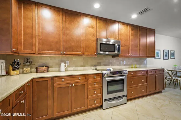 a kitchen with stainless steel appliances granite countertop wooden cabinets and a stove top oven