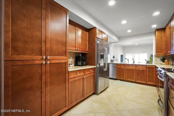 a kitchen with stainless steel appliances granite countertop a refrigerator and a sink
