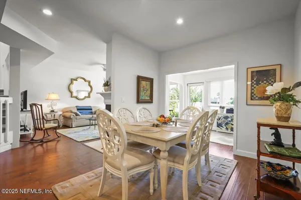 a view of a dining room with furniture a rug and wooden floor
