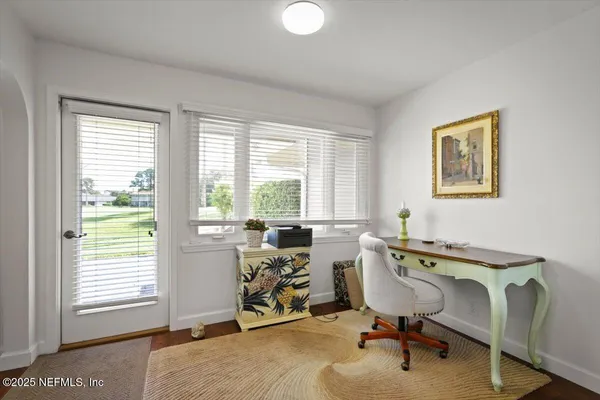a view of a workspace with furniture and a window