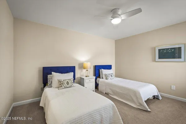 a bedroom with two bed and a ceiling fan