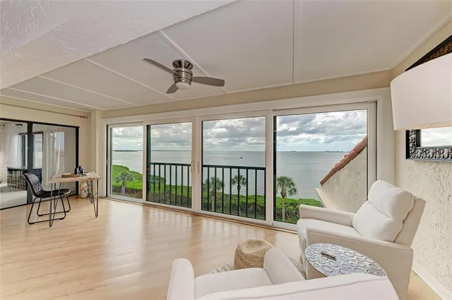 a living room with stainless steel appliances granite countertop furniture a fireplace a large window and kitchen view