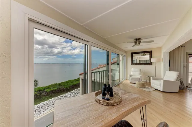 a kitchen with stainless steel appliances granite countertop a stove top oven a sink dishwasher a dining table and chairs with wooden floor