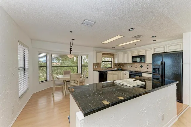 a kitchen with granite countertop a sink and cabinets