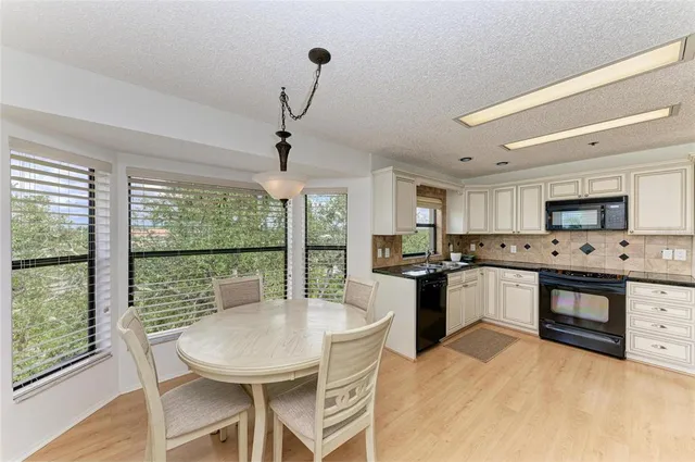a kitchen with white cabinets and chandelier