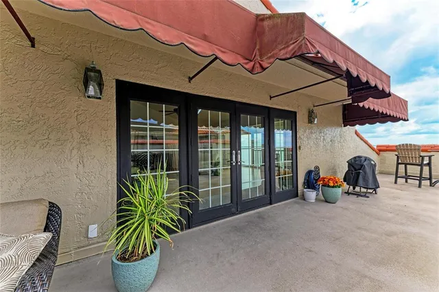 a patio with a table and chairs under an umbrella