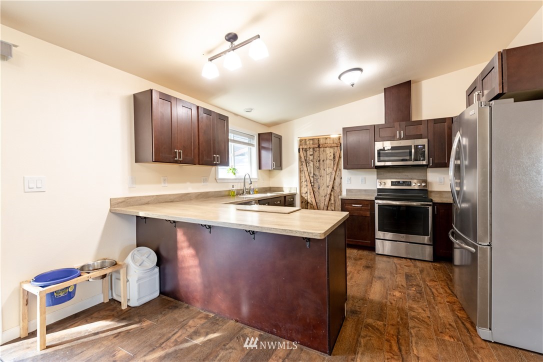 5425 188th Avenue Southwest Rochester, WA 98579 - Photo 12 of 40 a kitchen with granite countertop a sink appliances and cabinets