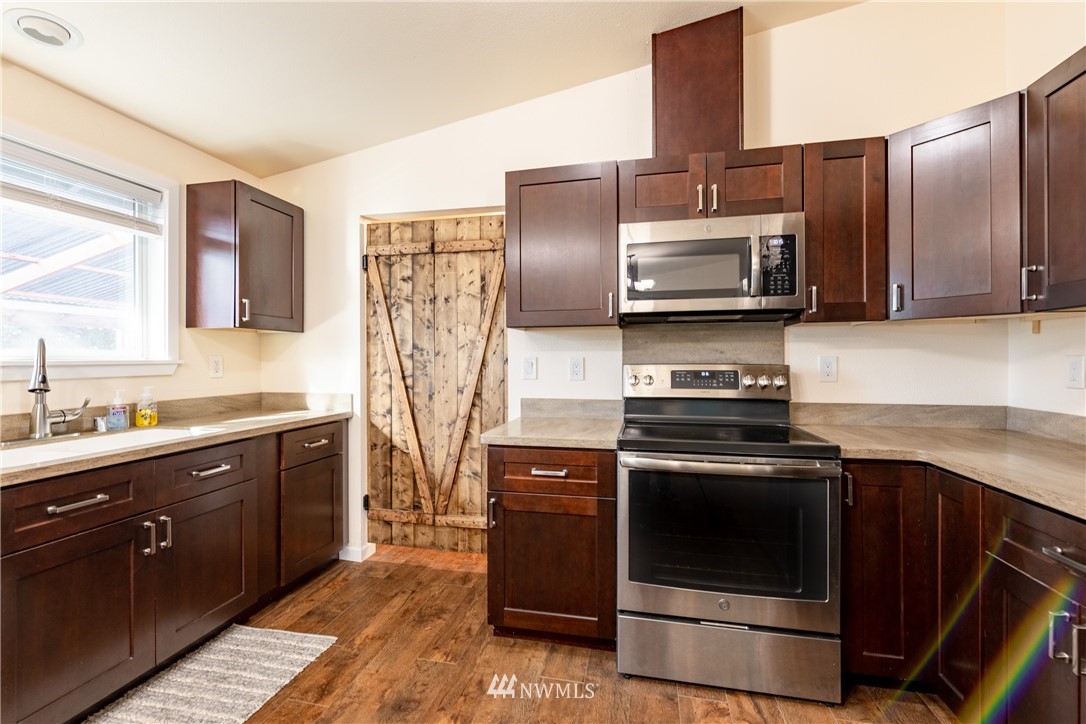5425 188th Avenue Southwest Rochester, WA 98579 - Photo 13 of 40 a kitchen with stainless steel appliances granite countertop a stove microwave and refrigerator