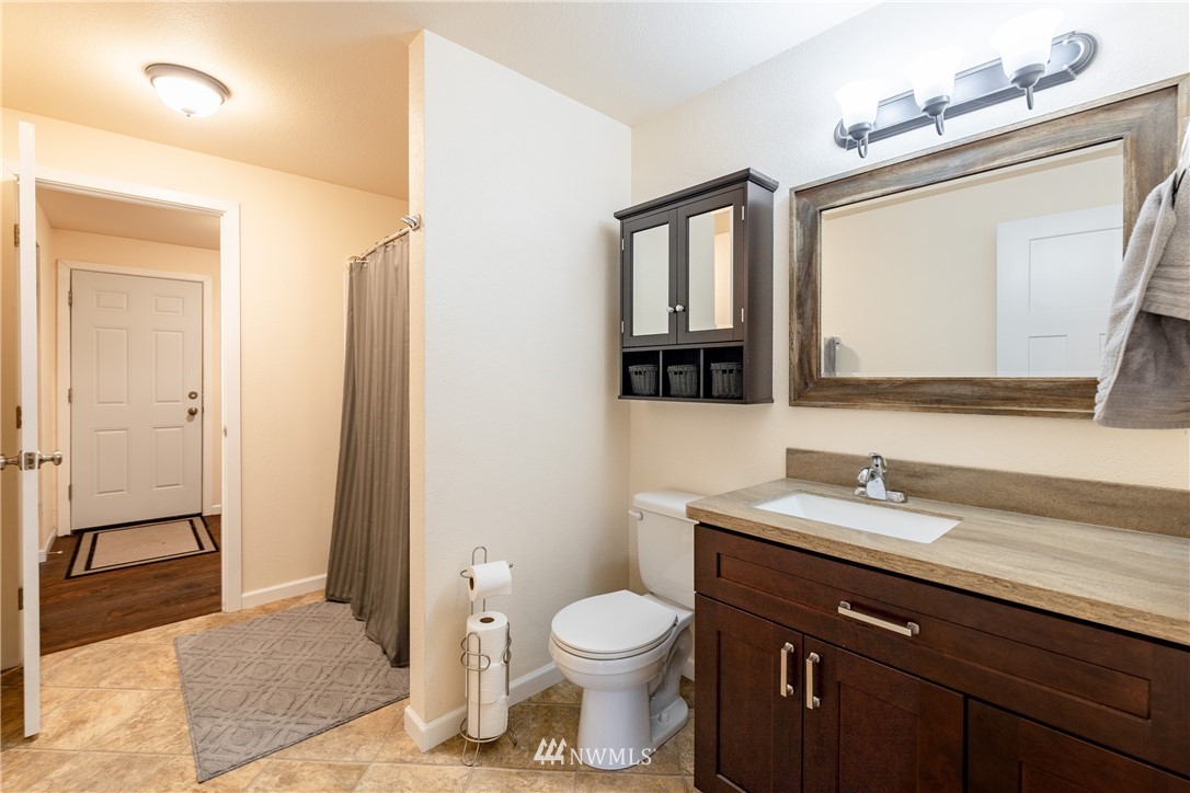 5425 188th Avenue Southwest Rochester, WA 98579 - Photo 21 of 40 a bathroom with a toilet a sink a mirror and a shower