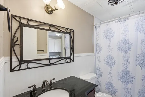a bathroom with a granite countertop sink a mirror and shower