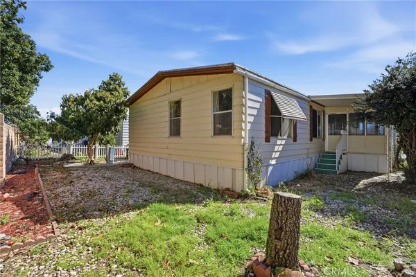 a view of a house with backyard and trees