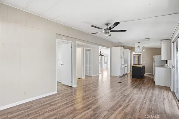 a view of a livingroom with wooden floor and a ceiling fan