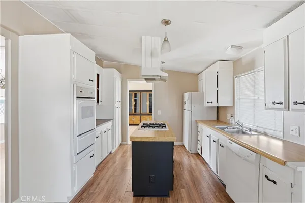 a kitchen with stainless steel appliances a refrigerator a stove a sink dishwasher and a stove with wooden floor