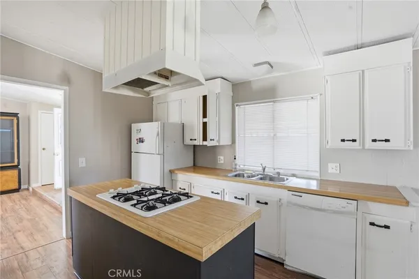 a kitchen with a stove a sink dishwasher and a refrigerator