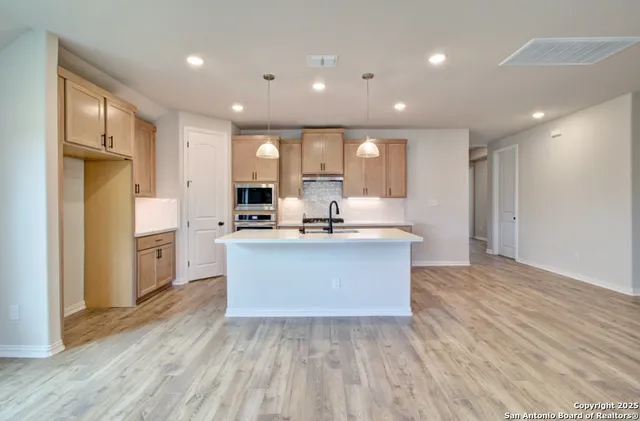 a view of kitchen with granite countertop refrigerator stove microwave and cabinets