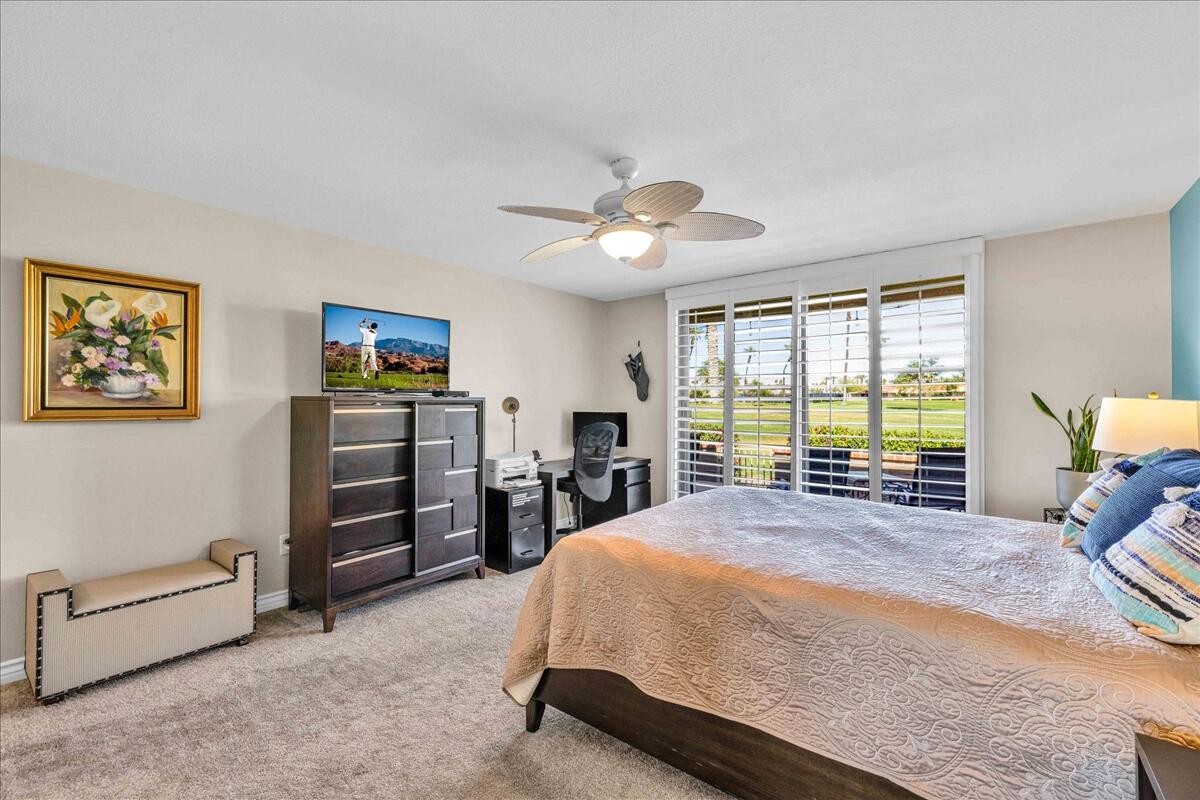 43 Sunrise Drive Rancho Mirage, CA 92270 - Photo 25 of 56 a spacious bedroom with a bed and a chandelier