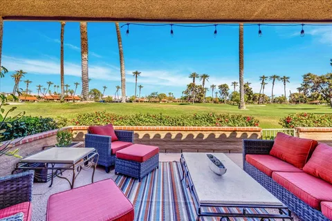 a outdoor sitting area with furniture and lake view