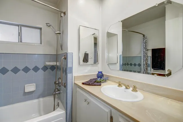 a bathroom with a bathtub sink vanity and mirror