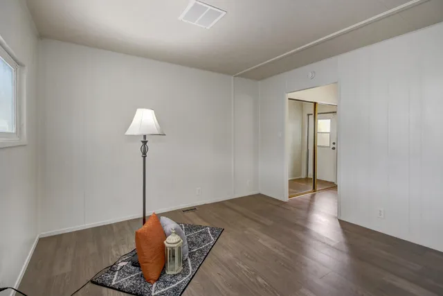 a view of a room that has a wooden floor and a window